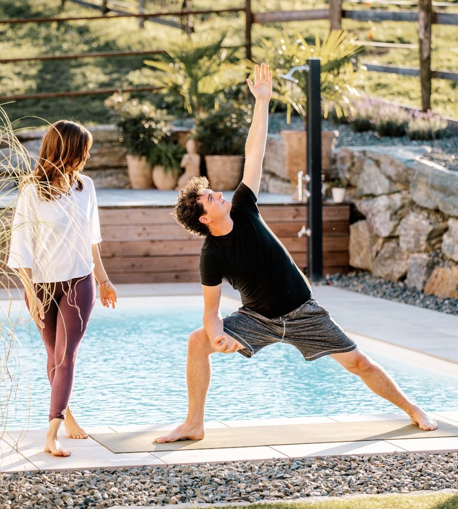 Am Foto sieht man Julia Wakonig-Wagner im Coaching mit jemandem. Sie unterrichtet Yoga.