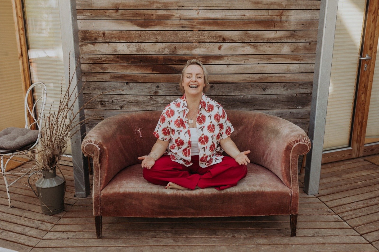 Die Yogini Dagmar Willnauer sitzt meditierend auf einem Sofa.